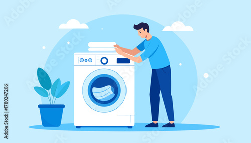 A young man in a blue shirt and pants doing laundry with a modern washing machine.