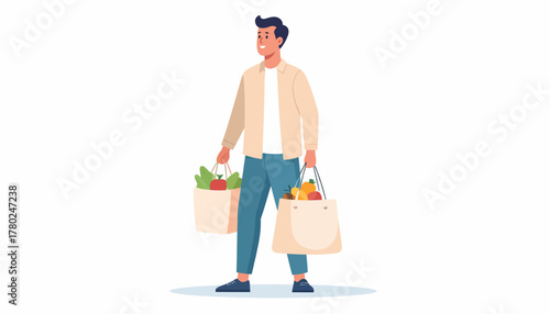 A young man in casual clothes stands holding two reusable tote bags filled with fresh groceries.