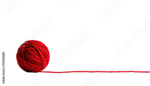 Bright red yarn ball with string trailing on a black background, textured, soft, and inviting, minimalist