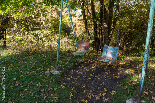 Tableau sur toile Decayed Swingset in Autumn Forest with Fallen Leaves on Ground