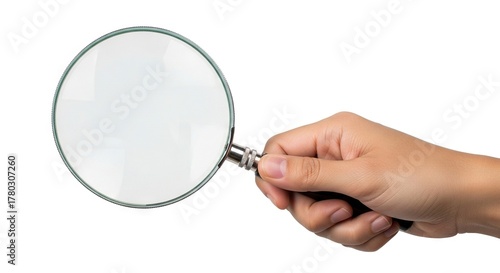 A hand holds a round magnifying glass with a silver frame against a white backdrop