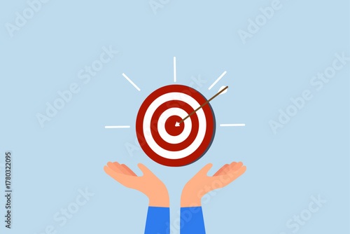 Goal, businessman hand hold target with arrow hit bullseye.