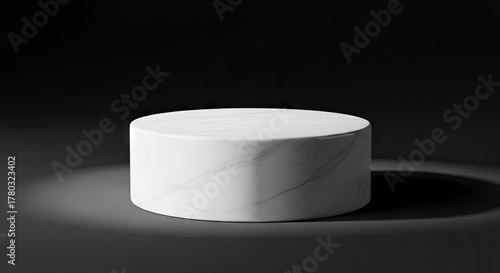 Cylindrical marble podium on a dark shadowed surface