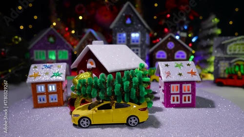 In front of the big Christmas town, a small town with cars and Christmas trees is spinning