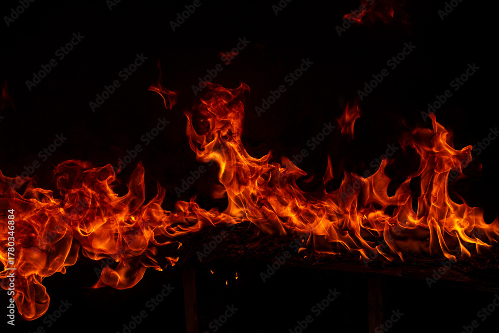 Fototapeta premium Fire blaze flames on black background. Fire burn flame isolated, abstract texture. Flaming explosion with burning effect. Fire wallpaper, abstract art pattern with copy space.