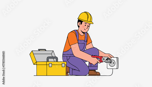 An electrician wearing a hard hat and overalls, kneeling and using pliers to fix an electrical outlet, with a toolbox nearby