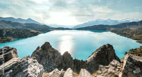 turquoise alpine lake surrounded by sharp rocky mountains under clear cold daylight