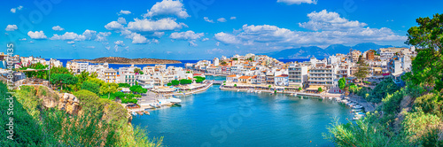 Travel Concepts. Picturesque View of Colorful Agios Nikolaos Village with Prodigious Voulismeni Lake Taken from View Point as Famous Travel Tourist Destination of Crete Island in Greece. Panorama Imag