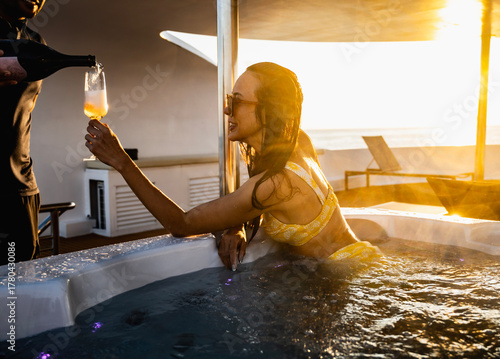 woman having sparkling wine in a hot tub in the Maldives