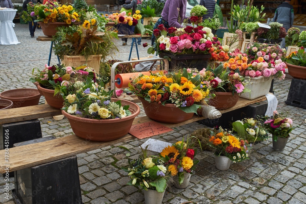 Obraz premium Market stall with a variety of flowers and plants for sale.