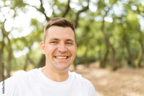 Happy adult man smiling looking at camera outdoors