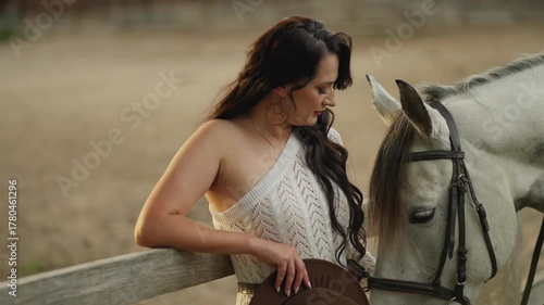 Woman in a revealing dress on a ranch near a horse. Concept of a beautiful horsewoman.
