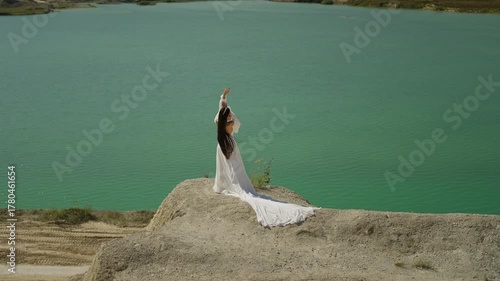 Bride in a white dress on the shore of the lake. Concept of a happy bride.