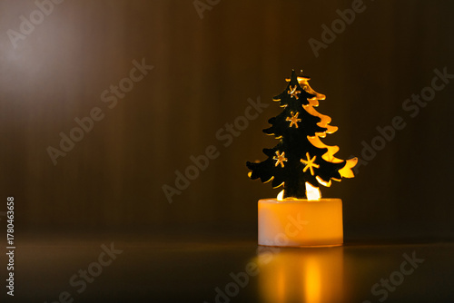 A cozy decorated Christmas tree with glowing lights and gift boxes on a wooden table 