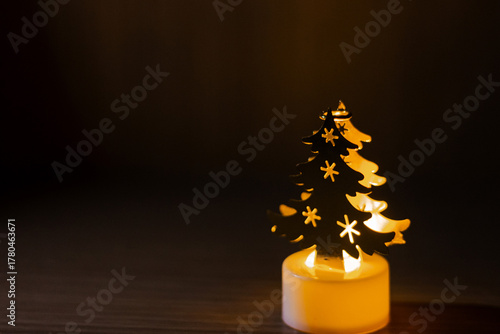 Christmas tree lamp glowing in the dark,It on the wood table and wood background.