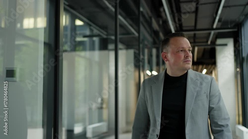 Confident businessman walking down the corridor of a modern office. Office worker concept.