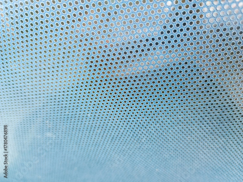 Close-up view at One Way Vision sticker film with dot pattern on glass. Blue concept design