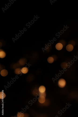 Golden blurred bokeh lights on black background. Glitter sparkle stars for celebrate. Overlay for your design. Bokeh effect golden light background. Golden Christmas concept. yellow sparkling bokeh