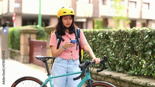 Asian female food delivery courier checking smartphone for directions