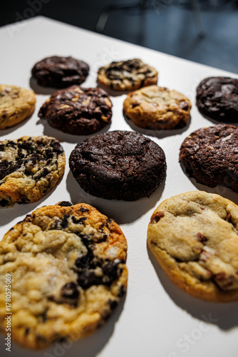 Wallpaper Mural Top-down view of assorted cookies including chocolate chip, double chocolate, white chocolate chunk, and cookies and cream, laid out in a grid on a white background with copy space Torontodigital.ca