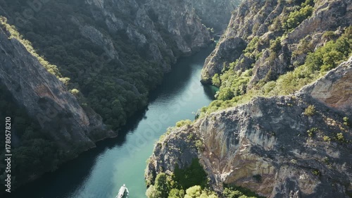 Stunning drone view of Matka Canyon near Skopje, a ship is sailing the river, 4k