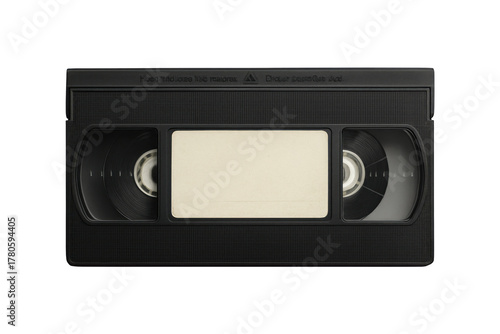 Close up of a black vintage vhs tape with a blank label in the center against a stark black background