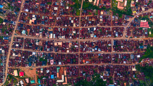 Aerial view of rooftops and roads interweave like threads in a rich tapestry, a mosaic of dwellings under the vast sky, Idanre, Ondo, Nigeria.
