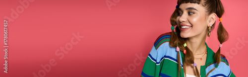Young woman smiling joyfully with colorful hairstyle in stylish outfit against vibrant background