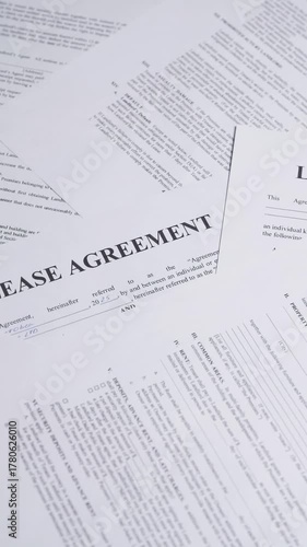 Lease agreement forms. Concept of renting a home. Rental agreement paperwork. Top view. Rotation. Document is mock-up