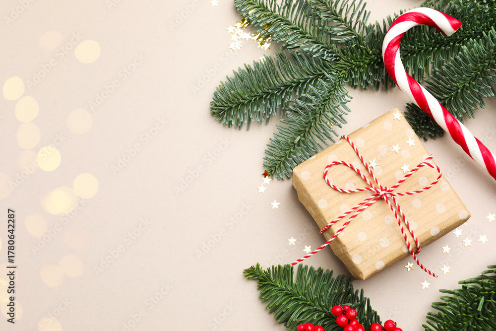 Naklejka premium Fir tree branches, gift and Christmas decor on light background, flat lay with bokeh effect. Space for text