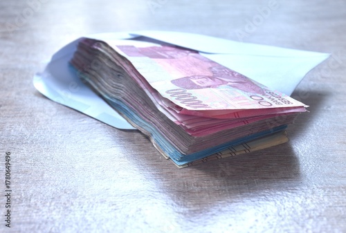 indonesia rupiah banknote in white envelope on wooden table 
