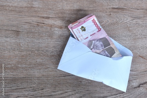 indonesia rupiah banknote in white envelope on wooden table 
