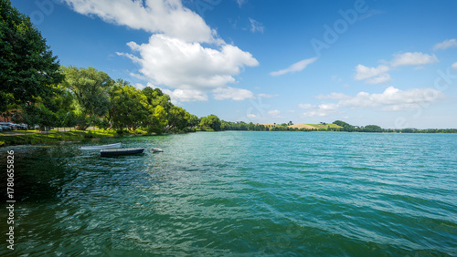 Beautiful turquoise lakes in the Kashubian region. Summer. Vacation vibe. Kashubian Switzerland. The town of Chmielno. Hills on the horizon. Poland. Lake Białe. Two empty boats moored on the lake.