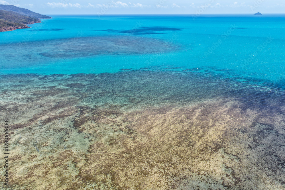 Obraz premium A breathtaking aerial view of Hydeaway Bay on Queensland’s Whitsunday Coast. The turquoise waters, white sandy beaches, and lush tropical landscape create a serene coastal paradise.