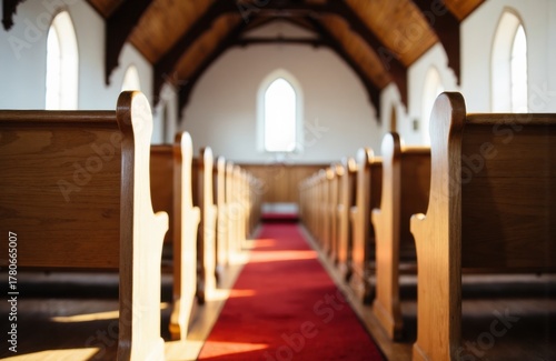 Empty church interior with wooden pews and arched windows creating a peaceful atmosphere