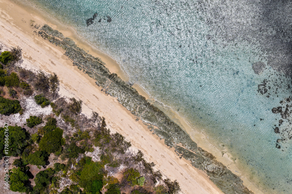 Obraz premium A breathtaking aerial view of Hydeaway Bay on Queensland’s Whitsunday Coast. The turquoise waters, white sandy beaches, and lush tropical landscape create a serene coastal paradise.
