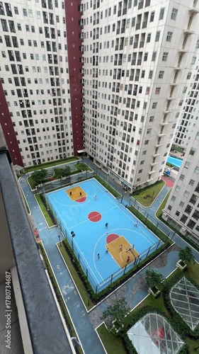 aerial bird eye view of a basketball court. basketball game on the sport field in an apartment residence. sport and leisure activity in park. outdoor basketball field court. people playing basketball