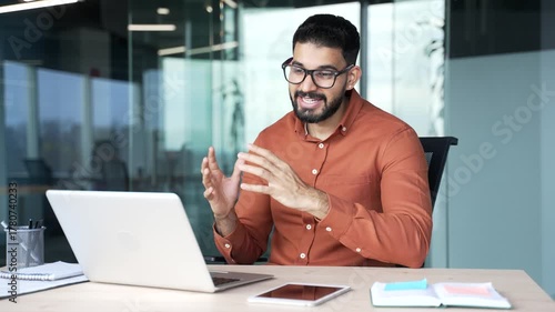 Confident businessman talking on video call conference using laptop sitting at workplace in office. Manager has a business meeting. Coach has online course, training, consultation or webinar remotely