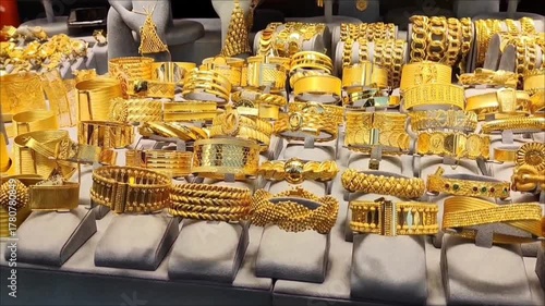 Beautiful women's jewelry gold bracelets with decorative patterns on the shop window.