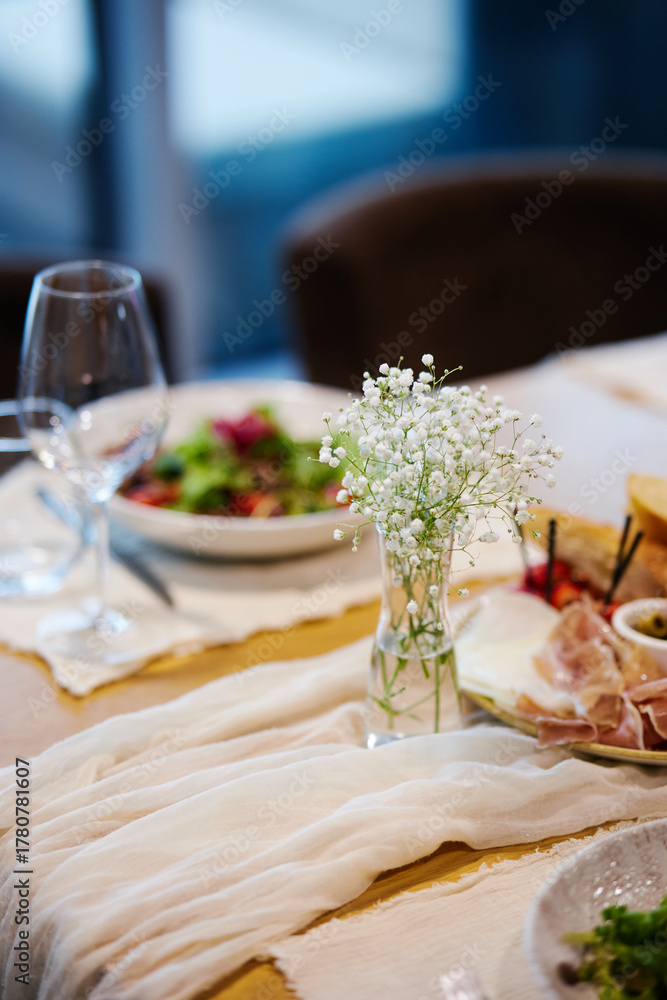 Fototapeta premium Fancy salad served on a white plate with champagne glass on the side in a restaurant background
