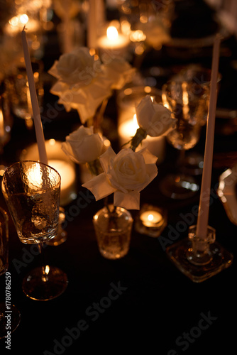 Luxurious setting of dark restaurant tables with candles and fresh flowers