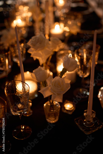 Luxurious setting of dark restaurant tables with candles and fresh flowers