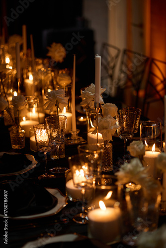 Luxurious setting of dark restaurant tables with candles and fresh flowers