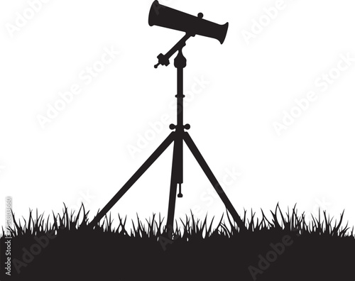 Black silhouette of a telescope on a tripod in grass