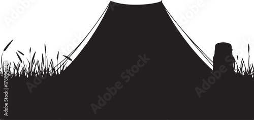 Black silhouette of a tent and tree stump in grassy field