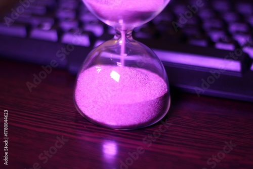 hourglass with the sand and computer keyboard time and work