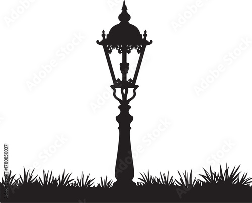 Black silhouette of ornate vintage lamppost on grass