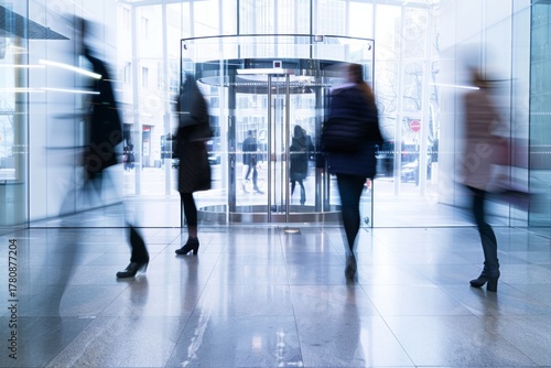 People walking through a revolving door in a modern building