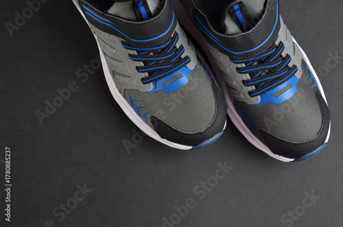 Gray sports sneakers on a black background.