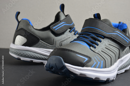 Gray sports sneakers on a black background.